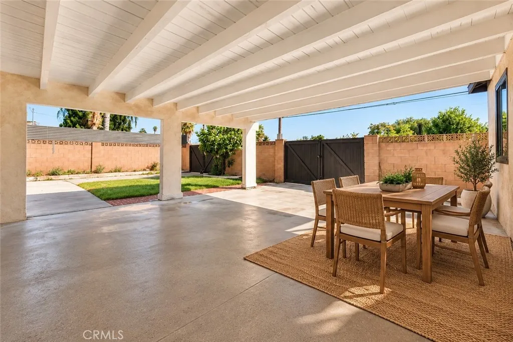 Outside, an oversized covered patio provides space for outdoor dining and gatherings while also accommodating covered parking. Two gated side-yard entrances offer additional vehicle access, and a lawn, colorful foliage, and landscaped planters enhance the backyard. A beautifully updated home with memorable architectural details and inviting spaces to enjoy inside and out! Photo is virtually staged. Outside, an oversized covered patio provides space for outdoor dining and gatherings while also accommodating covered parking. Two gated side-yard entrances offer additional vehicle access, and a lawn, colorful foliage, and landscaped planters enhance the backyard. A beautifully updated home with memorable architectural details and inviting spaces to enjoy inside and out! Photo is virtually staged.