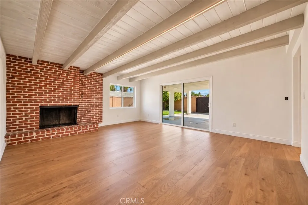The adjoining family room offers a beamed ceiling and striking floor-to-ceiling brick fireplace with raised hearth. A dining area and sliding glass door opening to the covered rear patio make this an inviting space for everyday living and entertaining. The adjoining family room offers a beamed ceiling and striking floor-to-ceiling brick fireplace with raised hearth. A dining area and sliding glass door opening to the covered rear patio make this an inviting space for everyday living and entertaining.