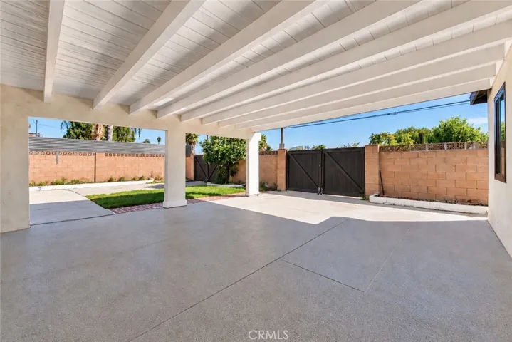 Outside, an oversized covered patio provides space for outdoor dining and gatherings while also accommodating covered parking. Two gated side-yard entrances offer additional vehicle access, and a lawn, colorful foliage, and landscaped planters enhance the backyard. A beautifully updated home with memorable architectural details and inviting spaces to enjoy inside and out!