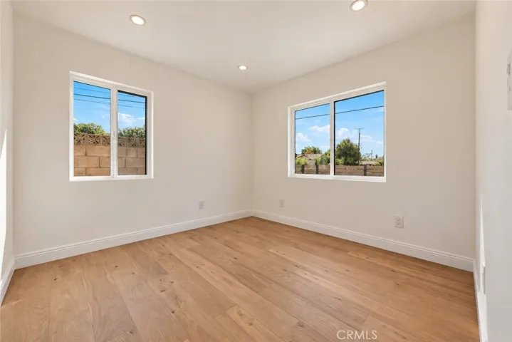 Two additional bedrooms and a beautifully remodeled secondary bath with mosaic tile flooring, floating wood vanity, black integrated trough sink, matte black fixtures, and custom-tiled step-in shower complete the bedroom wing.