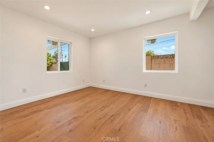 Two additional bedrooms and a beautifully remodeled secondary bath with mosaic tile flooring, floating wood vanity, black integrated trough sink, matte black fixtures, and custom-tiled step-in shower complete the bedroom wing.