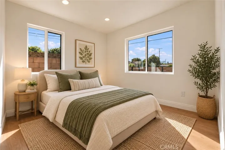 Two additional bedrooms and a beautifully remodeled secondary bath with mosaic tile flooring, floating wood vanity, black integrated trough sink, matte black fixtures, and custom-tiled step-in shower complete the bedroom wing. Photo is virtually staged.