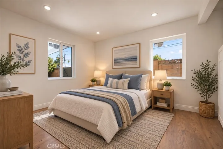 Two additional bedrooms and a beautifully remodeled secondary bath with mosaic tile flooring, floating wood vanity, black integrated trough sink, matte black fixtures, and custom-tiled step-in shower complete the bedroom wing. Photo is virtually staged.