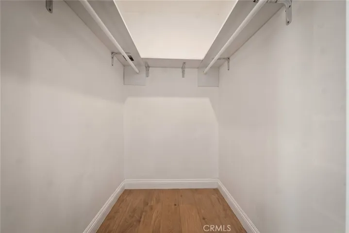 The primary suite features a walk-in closet and remodeled private bath with mosaic tile flooring, floating vanity, designer lighting, and custom-tiled tub/shower combination with glass panel.