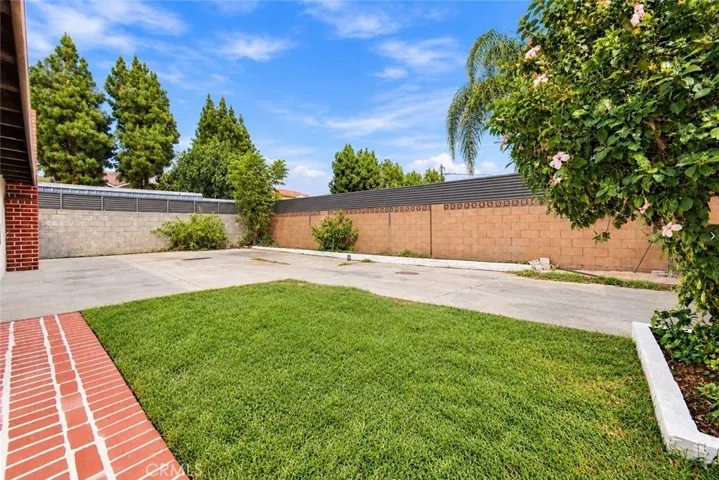 Outside, an oversized covered patio provides space for outdoor dining and gatherings while also accommodating covered parking. Two gated side-yard entrances offer additional vehicle access, and a lawn, colorful foliage, and landscaped planters enhance the backyard. A beautifully updated home with memorable architectural details and inviting spaces to enjoy inside and out!