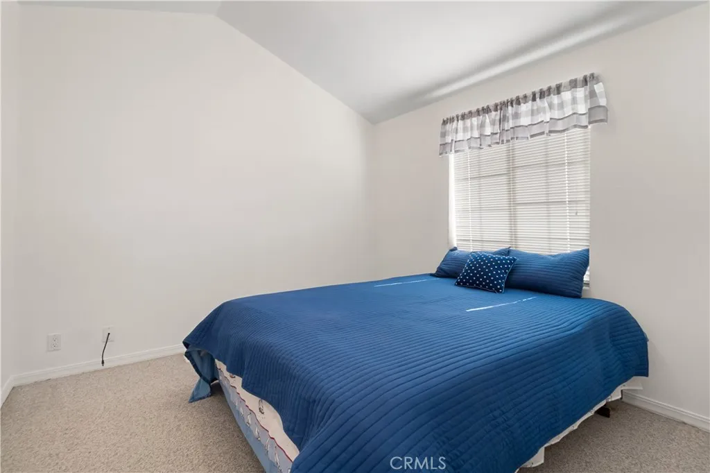 Bedroom entrance view with queen sized bed.  Wall to wall closet is in this bedroom but is not showing in the photo.  Closet doors are white.