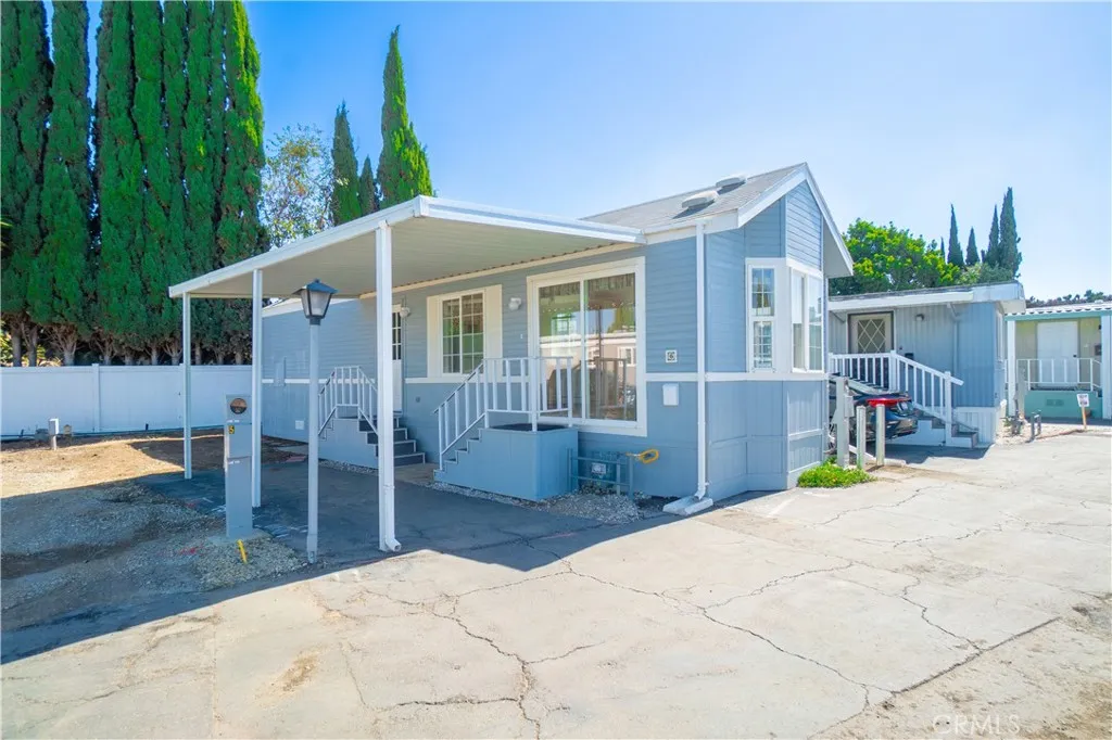 North side of home exterior with covered carport and two entrances.