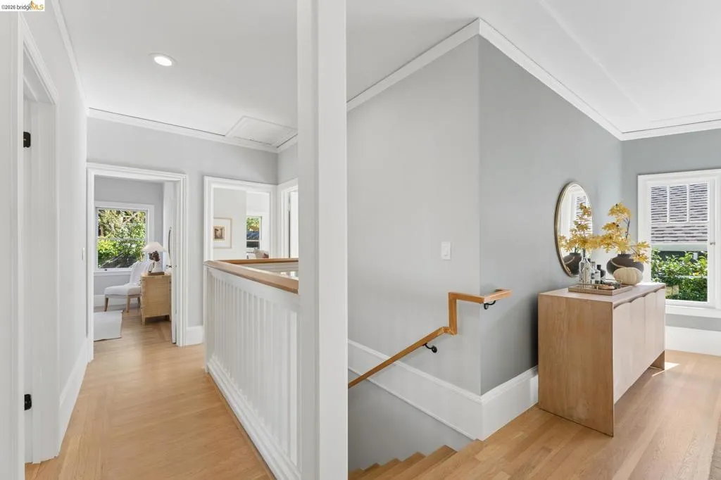 Hardwood flooring, white millwork, recessed lighting, and a custom wood-finished handrail with black iron hardware
