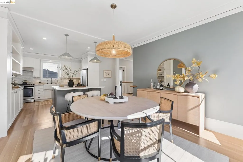 Kitchen featuring a center island, white cabinetry, a farmhouse-style sink, wood-finish flooring, and a textured pendant light fixture