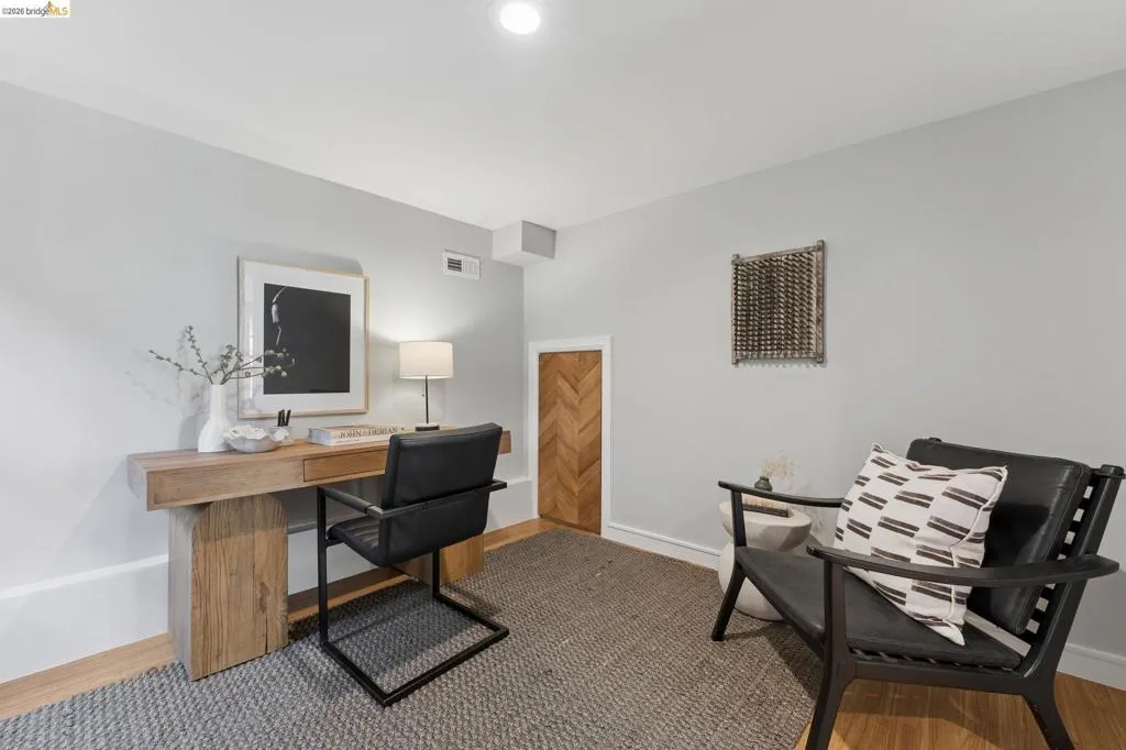 Neutral wall finishes, wood-finish flooring, and a built-in wood-paneled access door with a chevron pattern