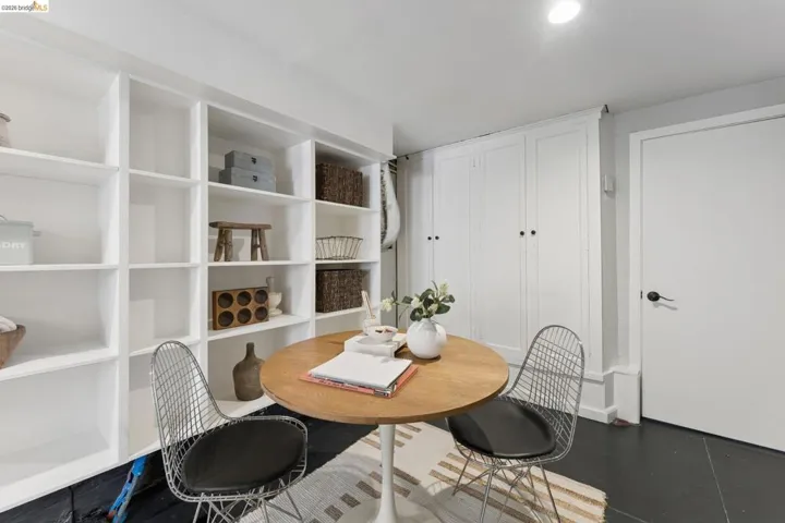 Custom white built-in floor-to-ceiling shelving and integrated white cabinetry with black hardware