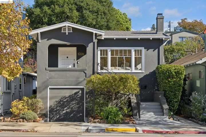 Craftsman-style exterior featuring a covered porch, multi-pane casement windows, an attached garage, and a concrete staircase with iron handrails