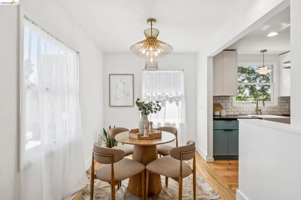 Dining area featuring wood-finish flooring, a tiered metal mesh chandelier, and dual windows