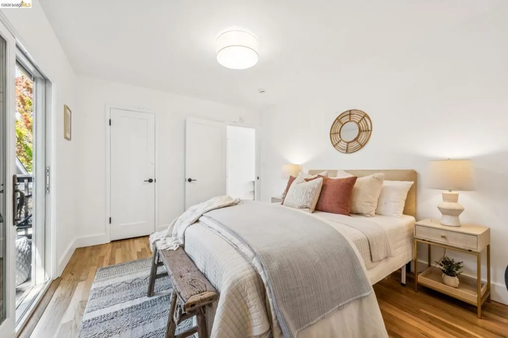Interior space featuring wood-finish flooring, white walls, flush-mount ceiling lighting, and a sliding glass door providing external access