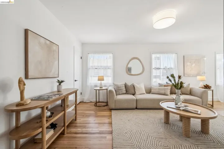 Living area featuring wood-finish flooring, dual-pane windows, and a flush-mount drum ceiling light fixture