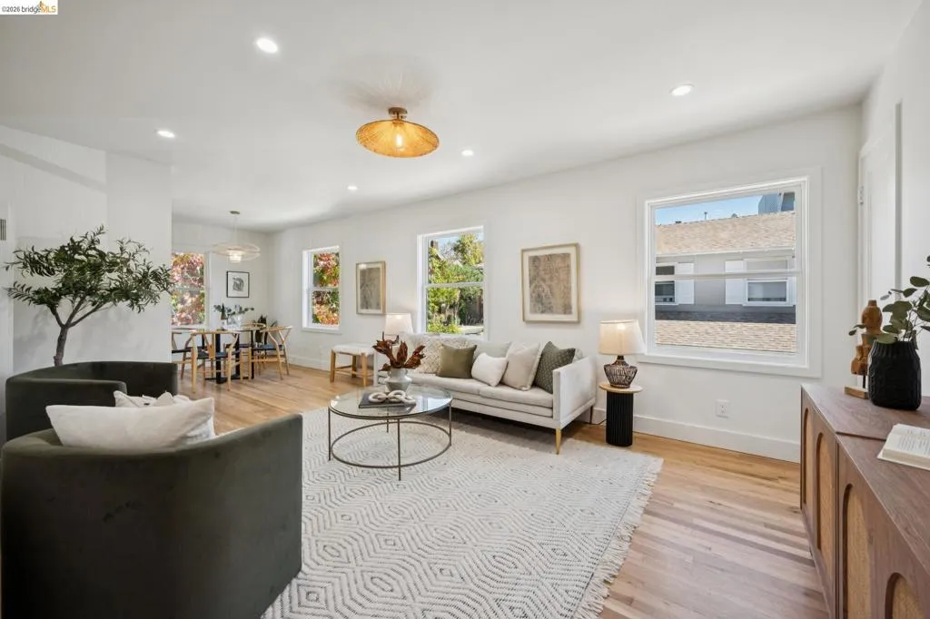 Living area featuring wood-finish flooring, recessed lighting, and multiple windows providing natural light