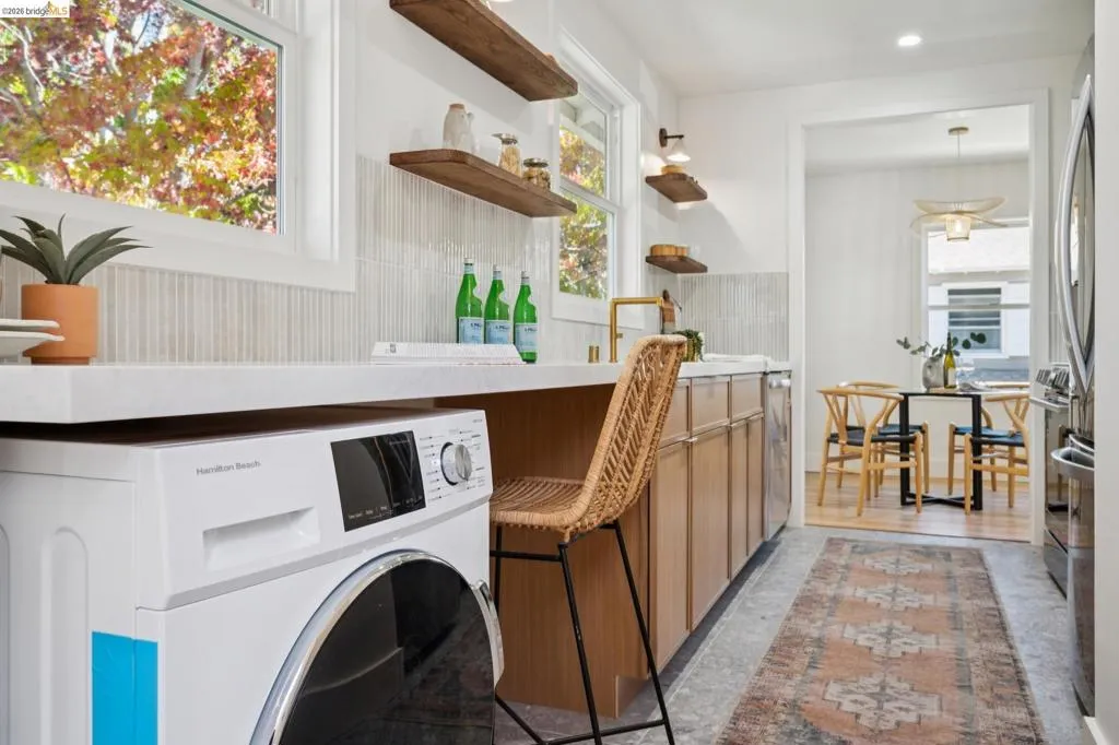 Kitchen featuring light wood cabinetry, quartz countertops, vertical tile backsplash, wall-mounted open shelving, and recessed lighting