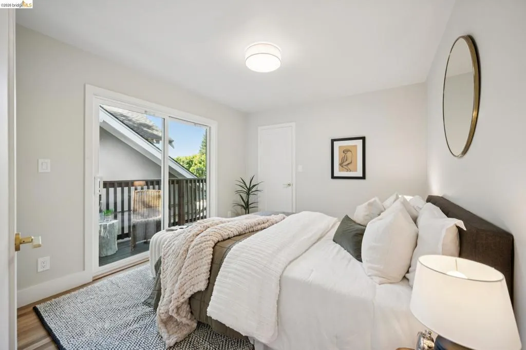 Sliding glass door with access to an exterior deck, wood-finish flooring, and flush-mount ceiling lighting