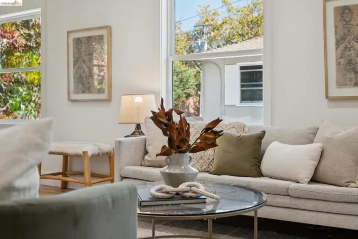 Living area featuring wood-finish flooring, white walls, and large double-hung windows