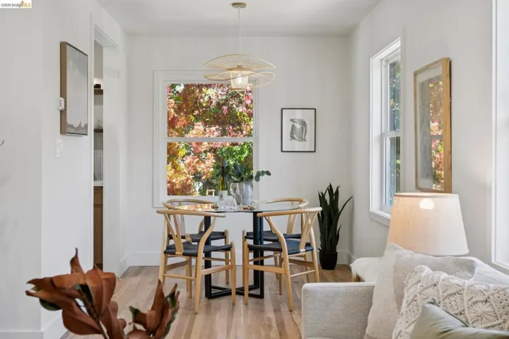 Dining space featuring wood-finish flooring, dual-pane windows, and a sculptural overhead pendant light
