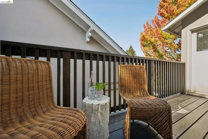Exterior balcony featuring wood-finish decking and a dark-toned vertical slat railing
