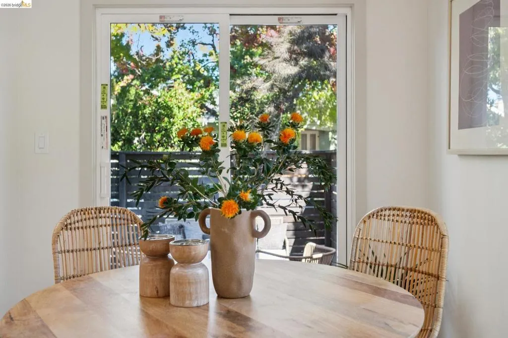 White-framed sliding glass door providing natural light and exterior access to a wood-slatted privacy fence