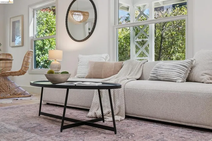 Living area featuring wood-finish flooring, multi-pane windows with grid detailing, and recessed wall trim