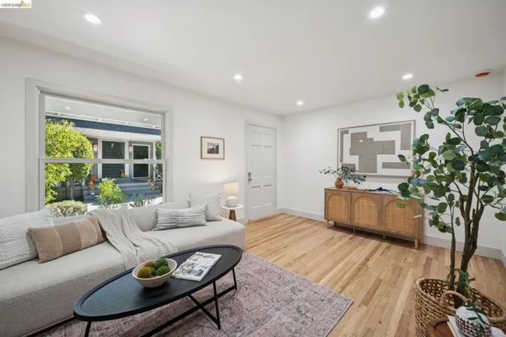 Living space featuring wood-finish flooring, recessed lighting, and a large multi-pane window