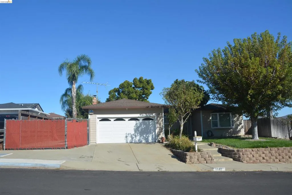 View of the front of the property from the street. note the extra wide driveway and adjustable RV/boat storage enclosure fencing.