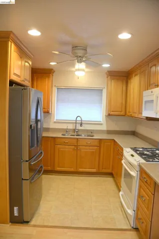 Remodeled kitchen with tile flooring, can lighting, and ceiling fan.