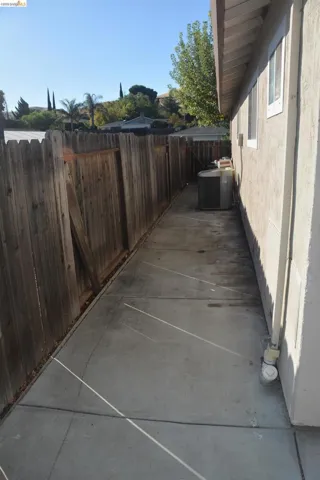 East side yard with concrete walkway and A/C unit