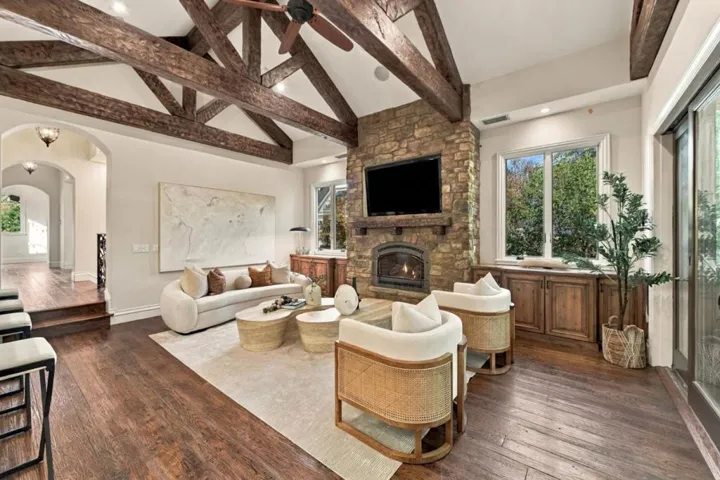 Family room with stone fireplace and exposed wood beams, Los Gatos