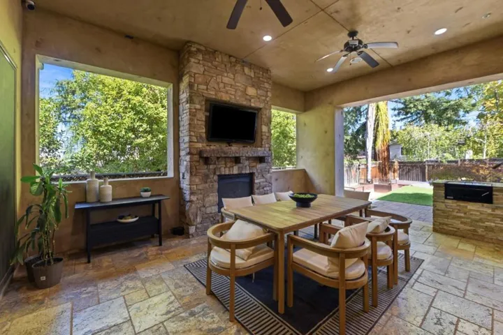 Loggia fireplace wall with TV and outdoor dining, Los Gatos
