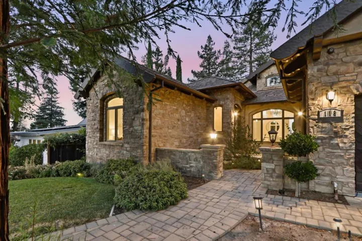 Stone entry courtyard and front elevation at dusk, Los Gatos