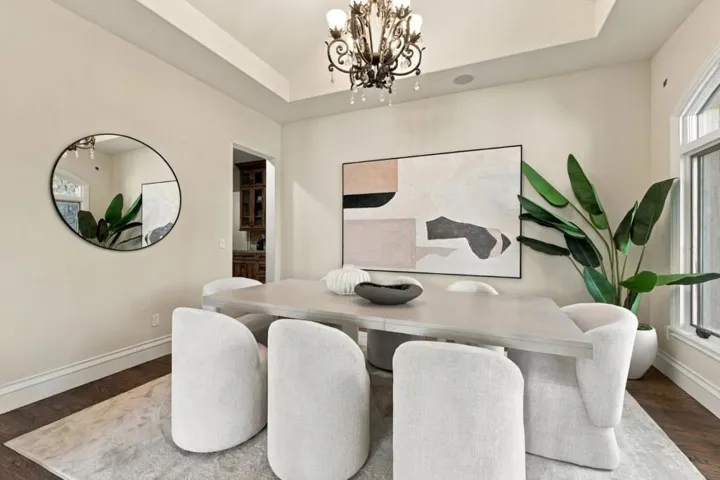 Dining room with chandelier, round mirror and oversized artwork, Los Gatos