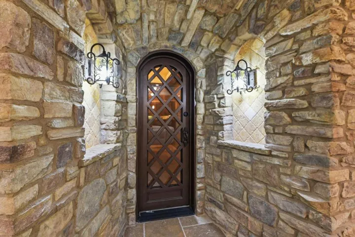 Stone archway with arched wood door and lantern sconces, Los Gatos