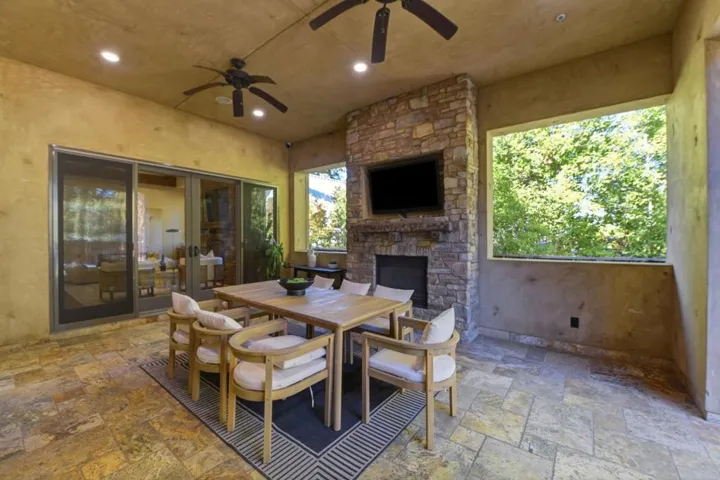 Loggia with stone fireplace, TV and outdoor dining, Los Gatos