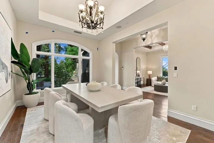 Dining table with chandelier and corner garden-view window, Los Gatos