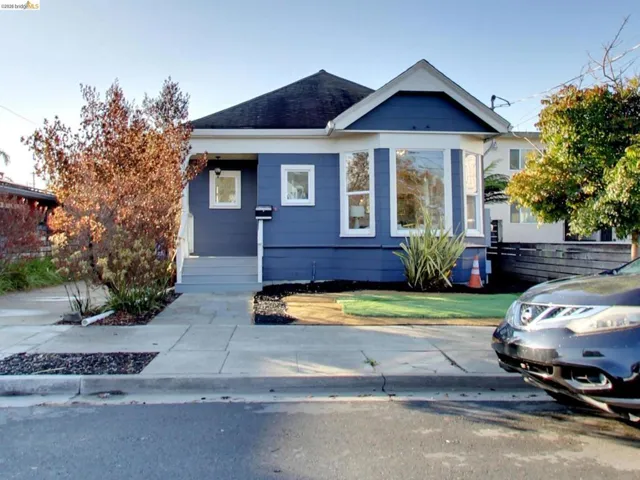 Exterior facade featuring blue horizontal siding, a covered front porch, and a large bay window
