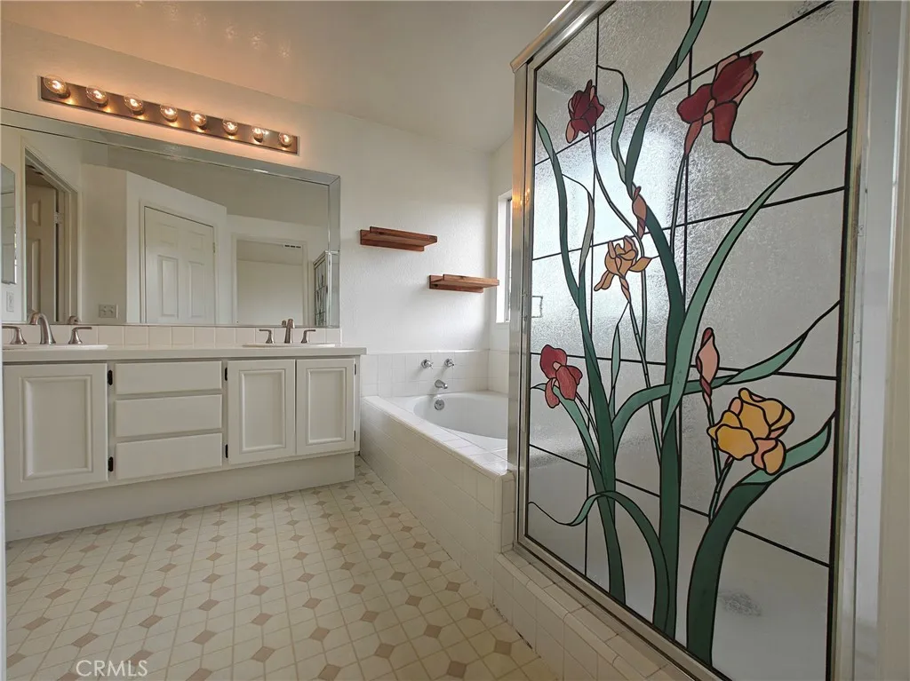 Master bath with dual sinks and separate tub and shower
