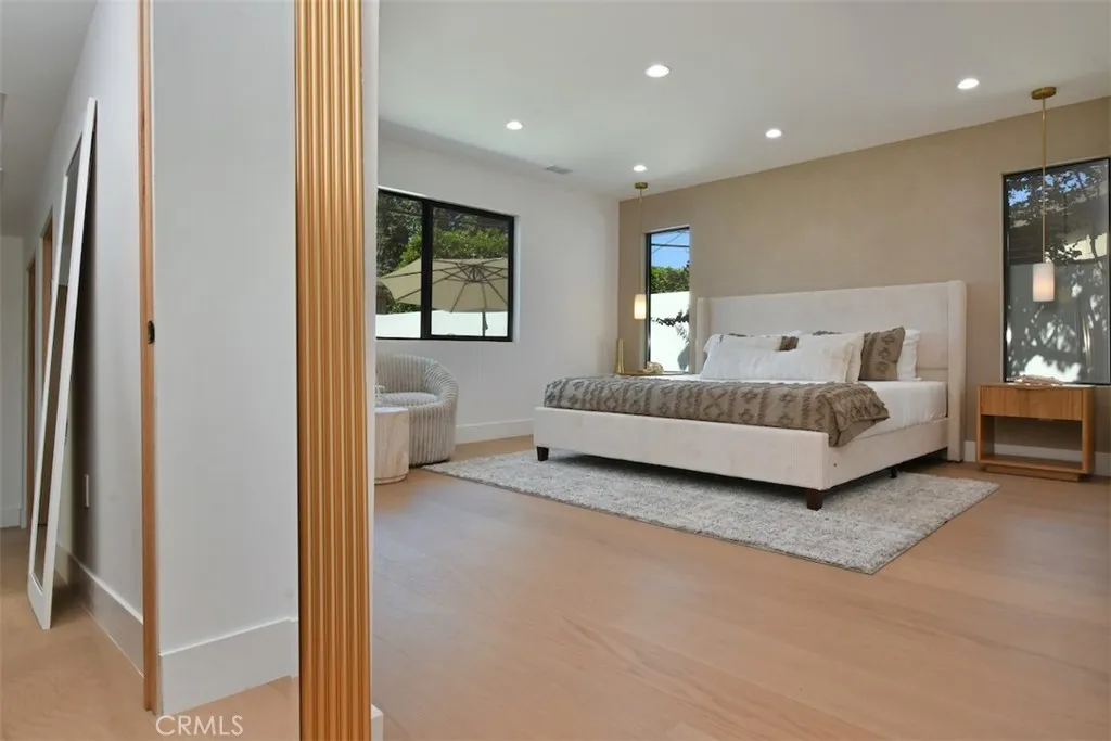 Primary suite featuring an expansive open layout, recessed lighting, Roman clay accent wall and rich engineered wood flooring. Primary suite featuring an expansive open layout, recessed lighting, Roman clay accent wall and rich engineered wood flooring.