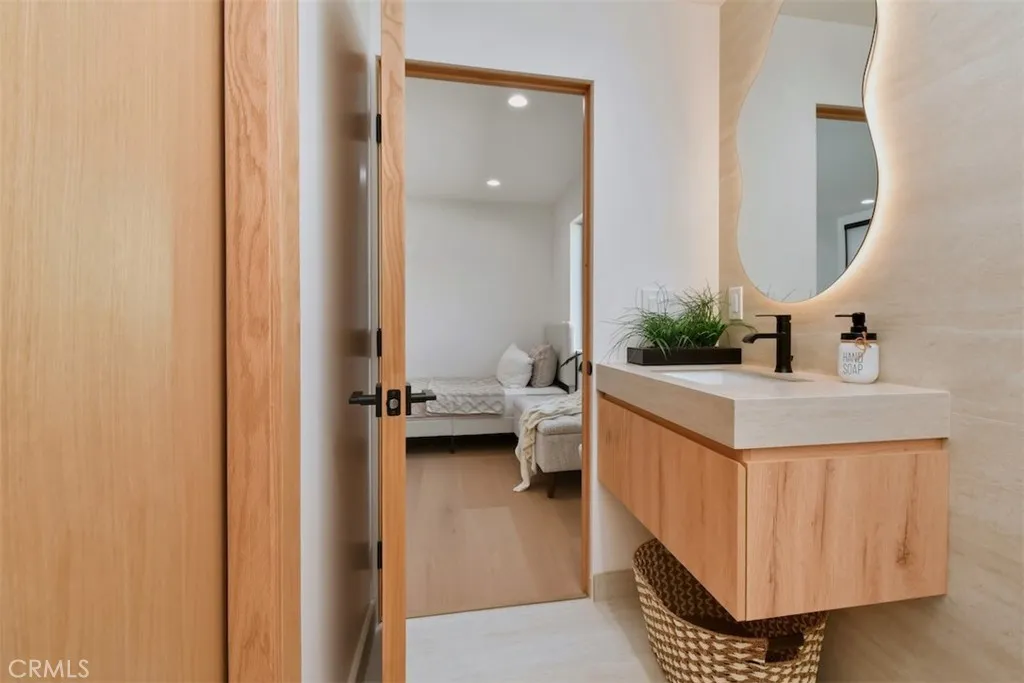 Modern bathroom featuring a warm wood vanity, vessel sink, and organic accent mirror.
Modern bathroom featuring a warm wood vanity, vessel sink, and organic accent mirror.