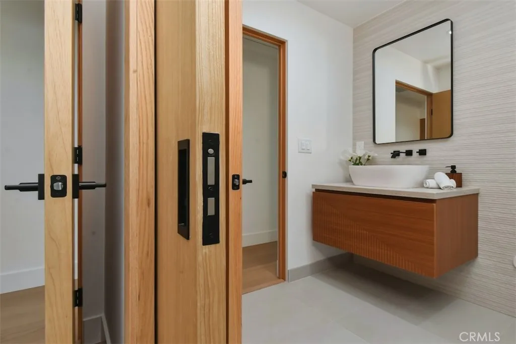 Updated bathroom showcasing a floating wood vanity, vessel sink, and modern matte black hardware. Updated bathroom showcasing a floating wood vanity, vessel sink, and modern matte black hardware.
