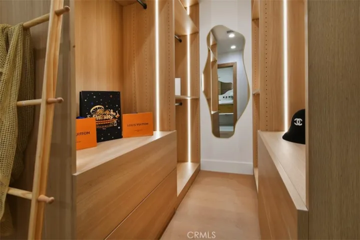  Detailed view of custom built-in primary closet organizer offering extensive storage and floating vanity space.