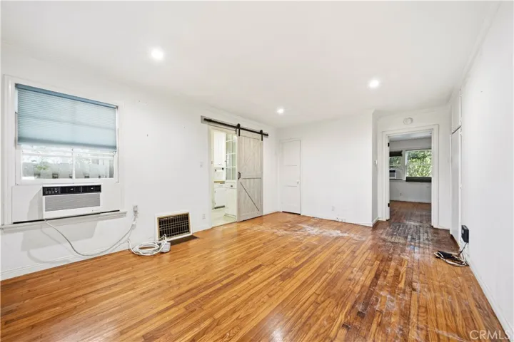 Living room with opening to the kitchen and view to the bedroom.