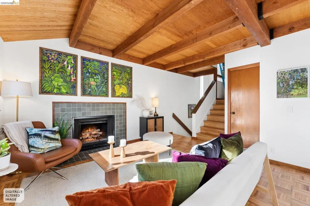 Vaulted wood-plank ceiling with exposed structural beams, parquet wood flooring, and a fireplace featuring a square-tiled surround