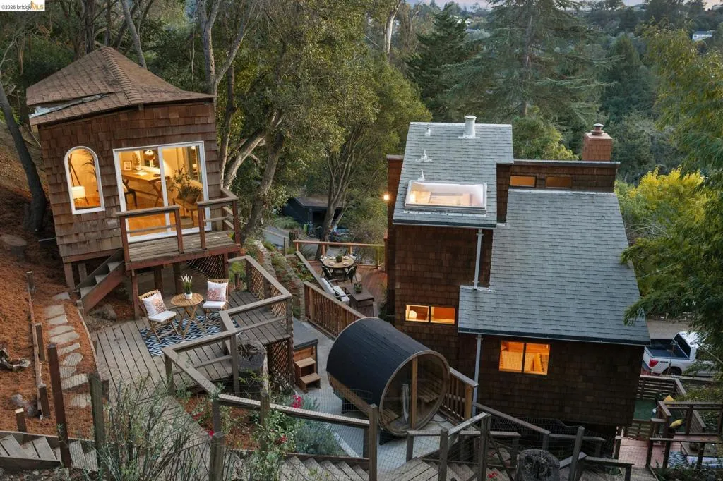 Multi-level wood-shingle exteriors featuring an elevated deck, roof skylight, chimney, and stone-tiled patio