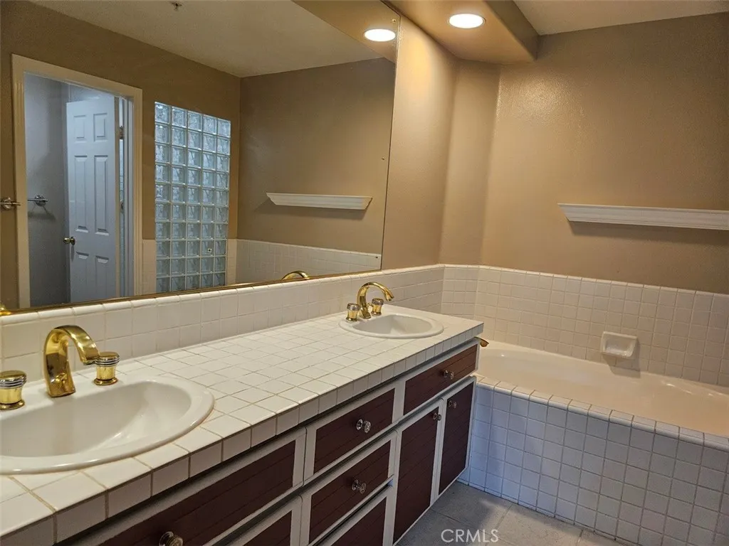 Double vanity, soaking tub, and walk-in shower in primary bath.