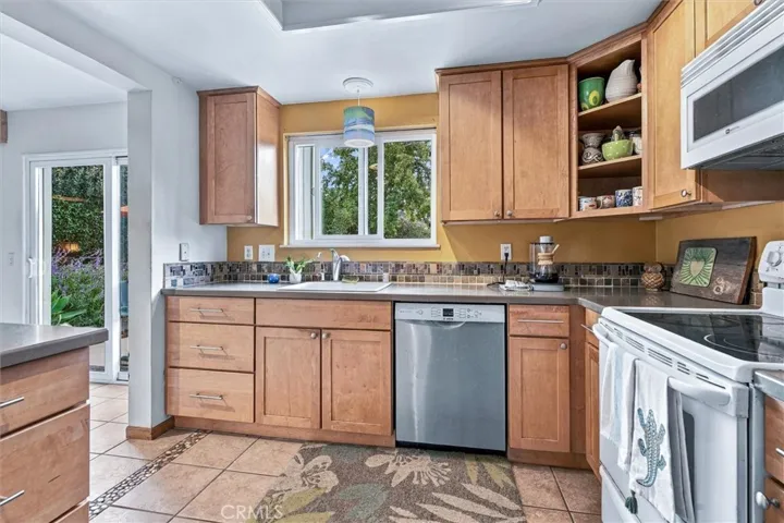 Great storage combined with artsy touches really gives this kitchen personality.  This kitchen not only opens to the dining and den areas but it also opens to the back yard.