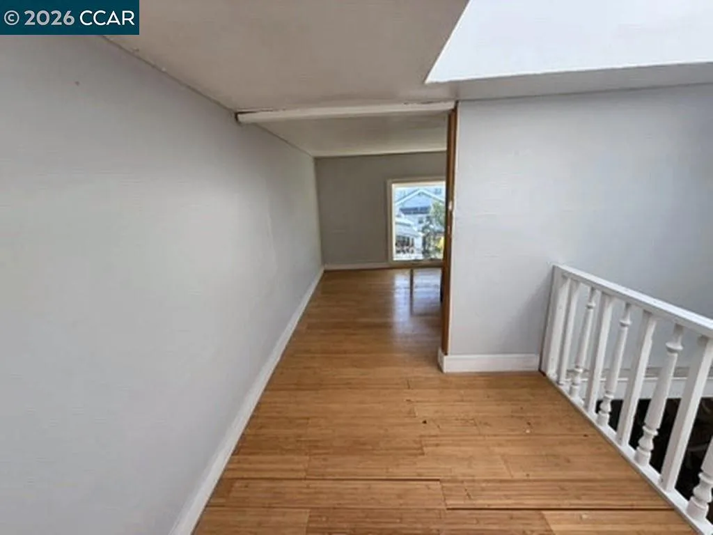 Upper level: hallway with railing. Digitally altered: personal property and debris removed. Unaltered photo available.